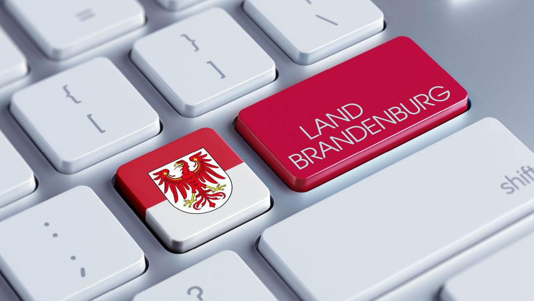 Eine weiße Tastatur mit zwei Tasten die, die Brandenburger Flagge links und rechts mit der Aufschrift Land Brandenburg