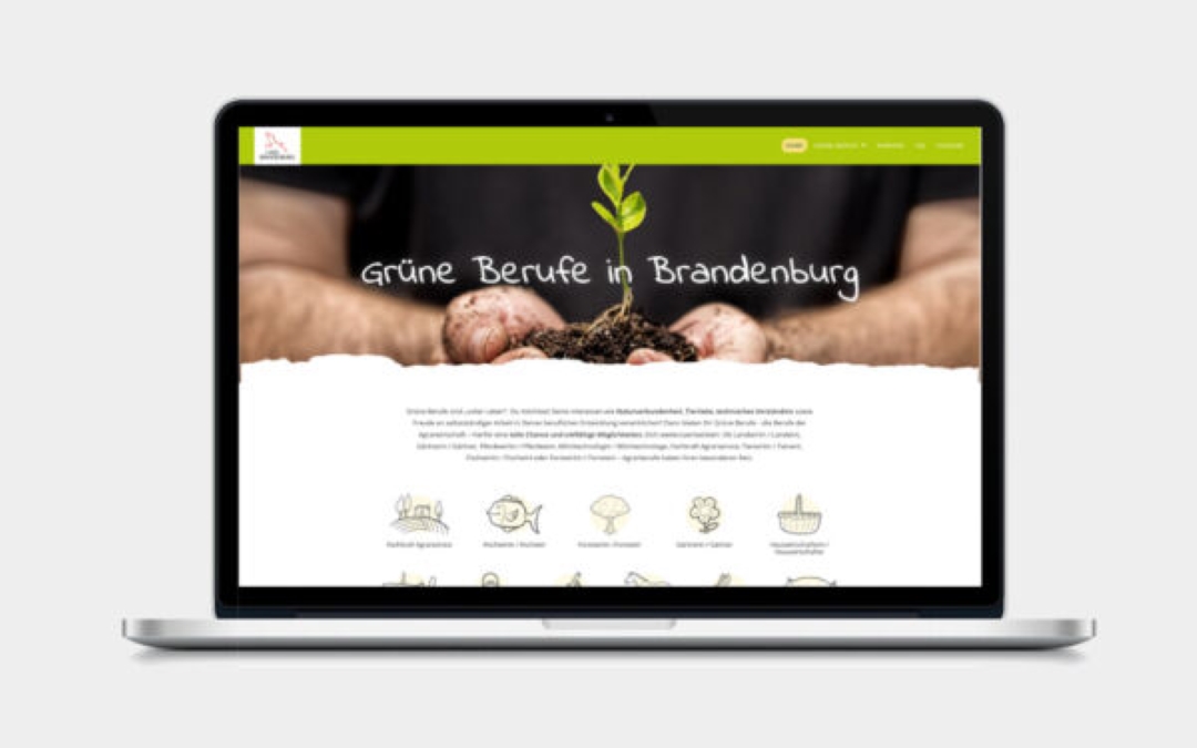 Laptop aufgeschlagen mit der Internetseite Grüne Berufe in Brandenburg. Ein Mann hält Erde und eine Pflanze in der Hand.